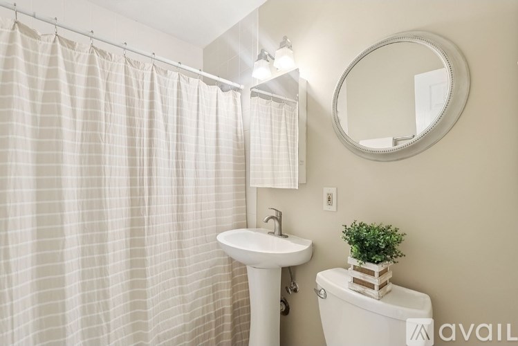 A bathroom with a white sink, toilet, and shower curtain.