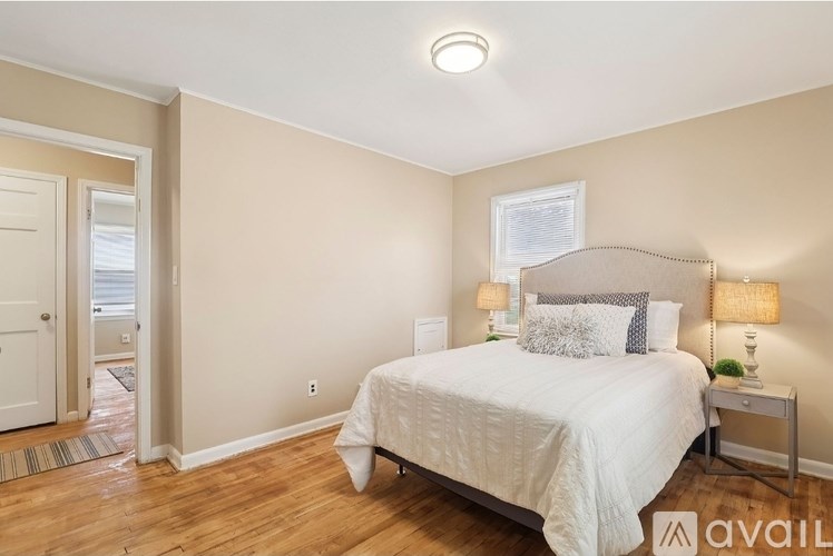 A bedroom with a bed, nightstand, and lamp.