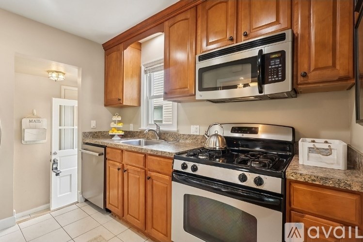 A kitchen with wooden cabinets and a stove top oven.