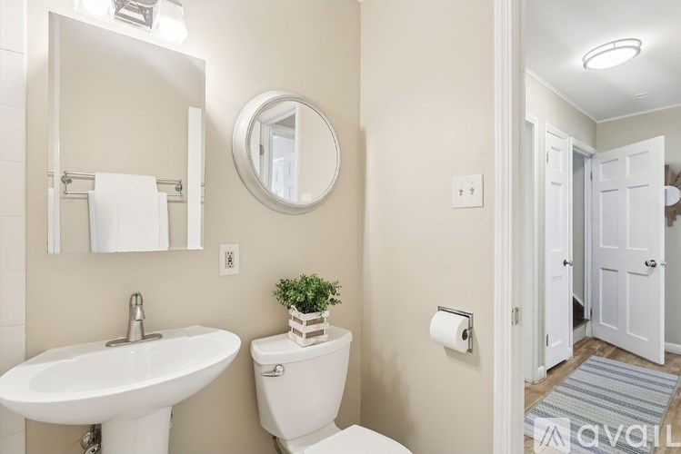 A white toilet sits next to a white sink in a bathroom.