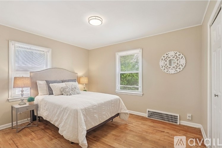 A bedroom with a bed, two lamps, and a window.
