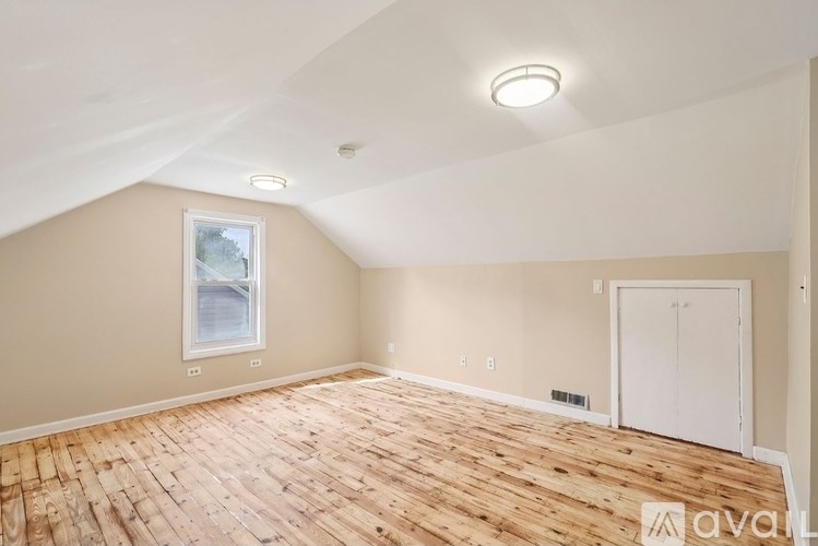 A room with wooden flooring and a window.