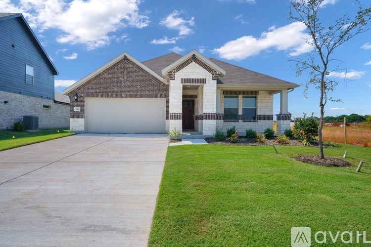 A house with a brick facade and a large driveway.