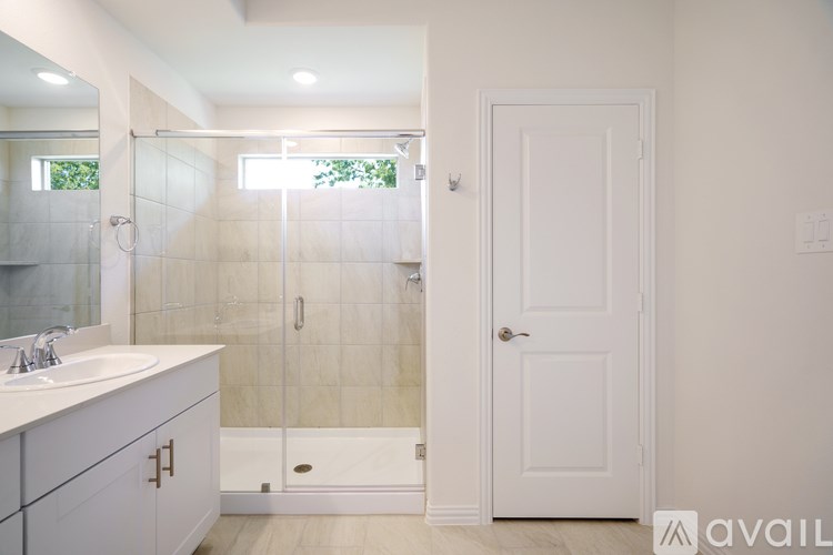 A bathroom with a white door and a white sink.