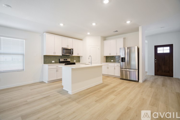 A kitchen with white cabinets and a wooden floor.