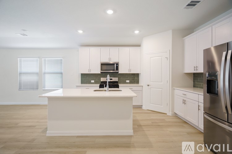 A kitchen with white cabinets and a large island.