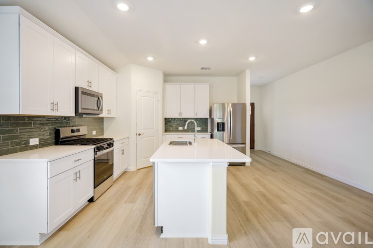 A kitchen with white cabinets and a wooden floor.