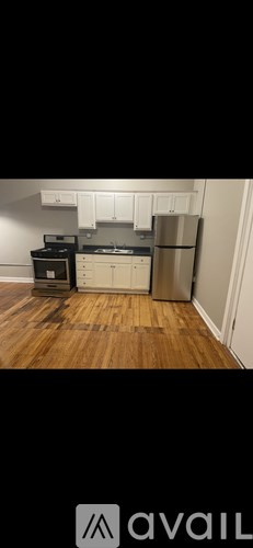 A kitchen with wooden floors and white cabinets.