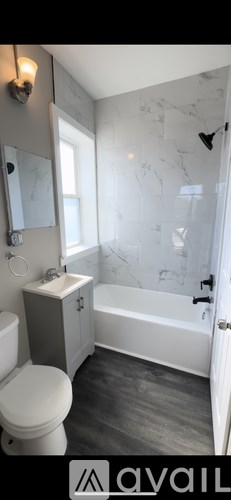 A bathroom with a toilet, sink, and bathtub.