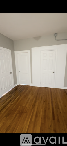 A room with wooden floors and white doors.