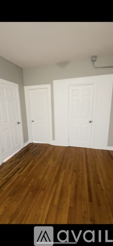 A room with wooden floors and white doors.