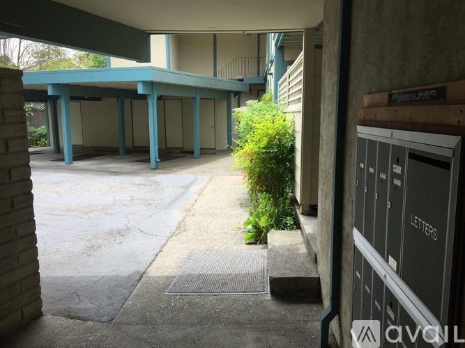 A concrete walkway leads to a building with a blue roof.