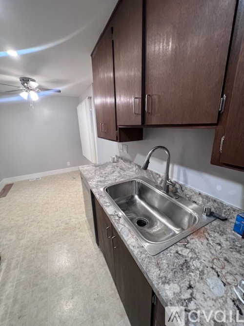 A kitchen with a sink and brown cabinets.