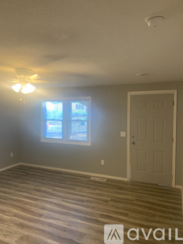 A room with a wooden floor and a white door.