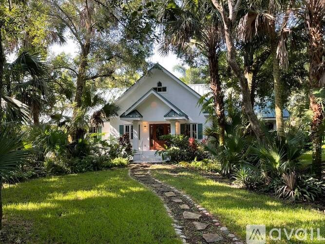 A house with a white roof and a stone pathway leading to the front door.