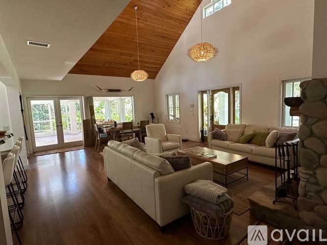 A living room with a white couch and a wooden ceiling.