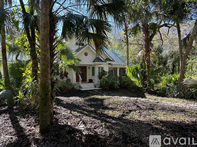A house surrounded by trees in a sunny day.