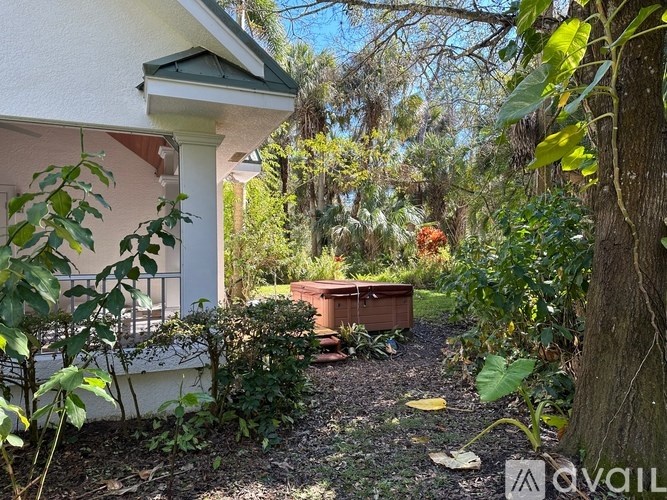 A white house with a garden in front.