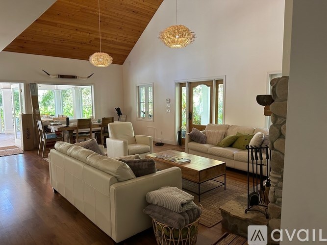 A living room with a white couch and a wooden ceiling.