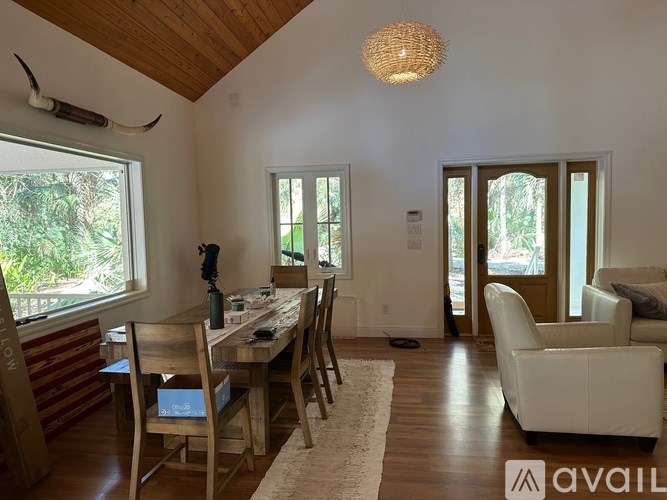 A dining room with a wooden table and chairs.