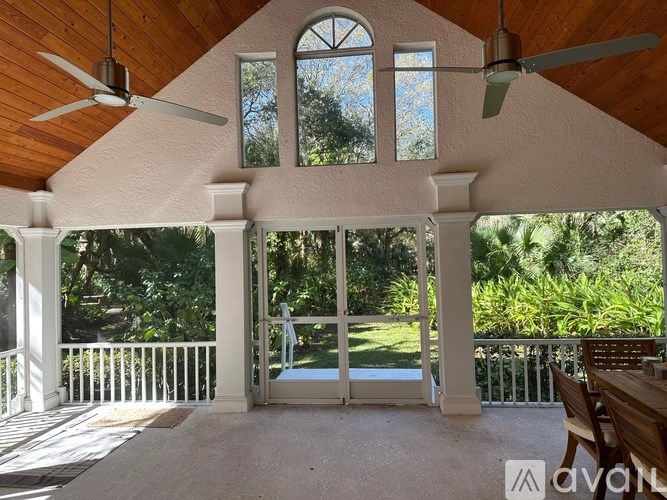 A wooden balcony with a table and chairs.
