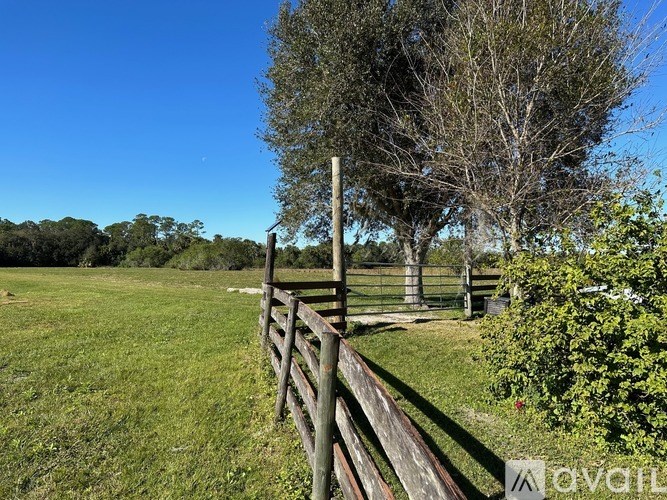 A wooden fence runs along a grassy field.