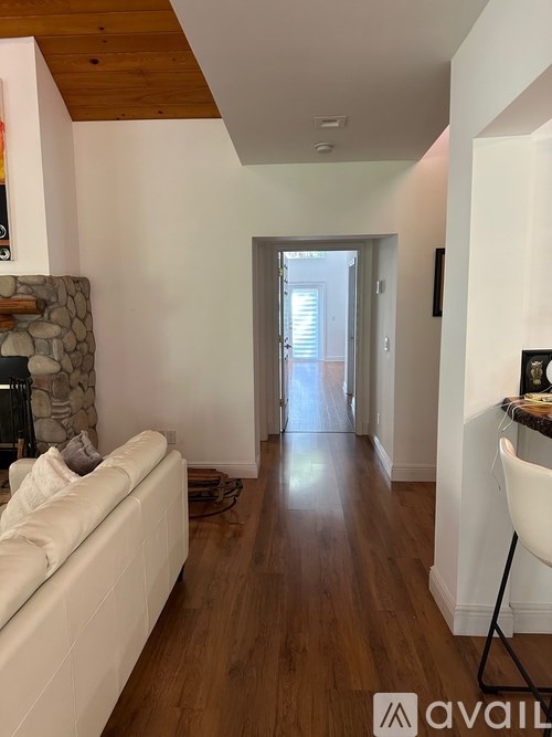 A living room with a white couch and a wooden floor.
