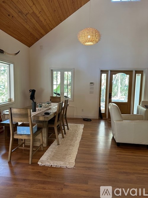 A dining room with a wooden table and chairs.