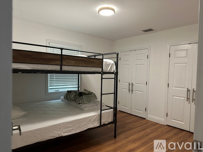 A room with bunk beds and wooden floors.