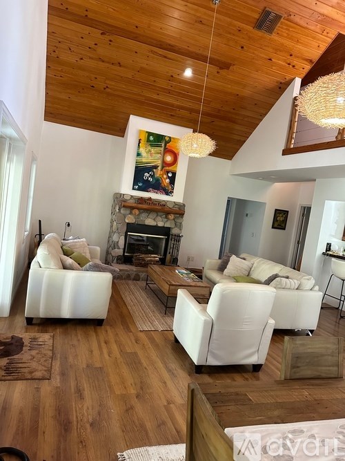 A living room with a fireplace and a painting hanging above it.