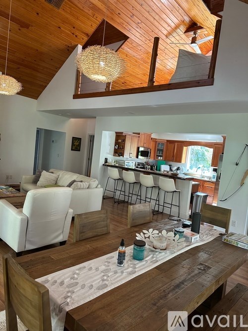 A living room with a wooden floor and a large mirror on the wall.