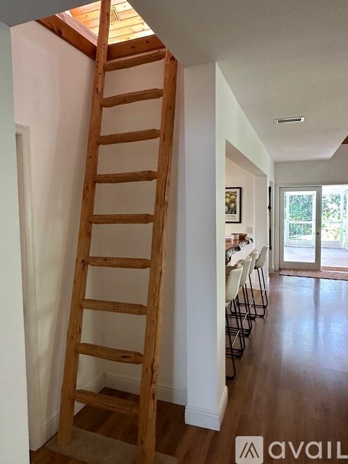 A wooden ladder is leaning against a wall in a room.