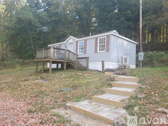 A small house with a porch and stairs leading up to it.