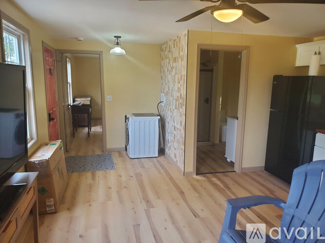 A living room with a television, a chair, and a fan.