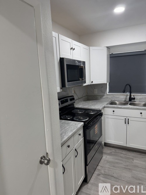 A kitchen with white cabinets and a black stove top.