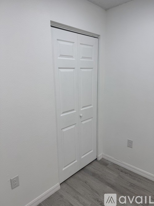 A white door in a room with a grey floor.