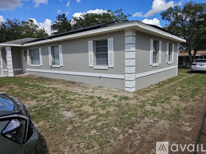A small house with a car parked in front.