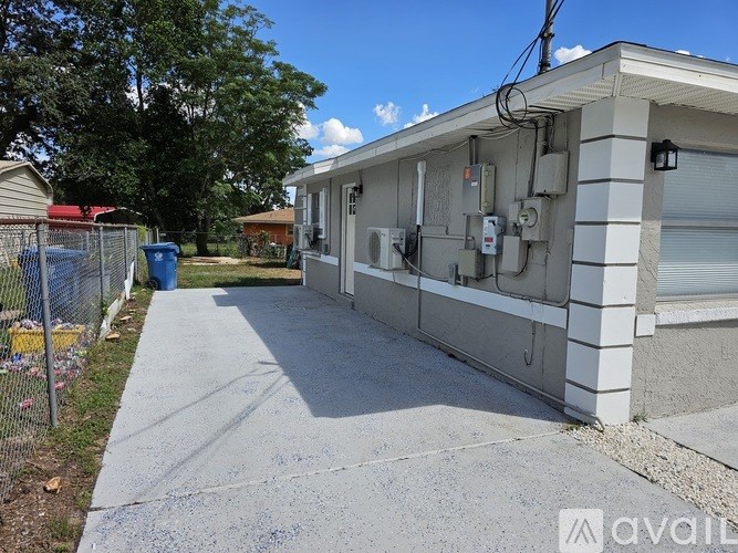A concrete driveway leads to a house with a garage.