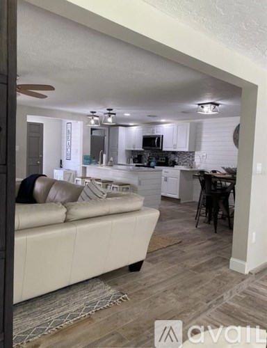 A modern kitchen with a white couch and a dining table.