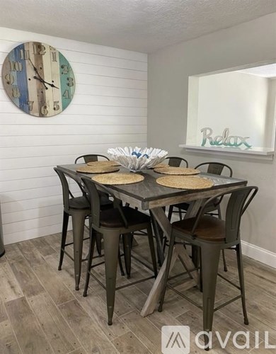 A dining table with chairs and a clock on the wall.