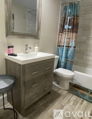 A bathroom with a sink, toilet, and a mirror.