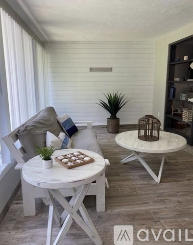A white chair with a potted plant on a table in a room.