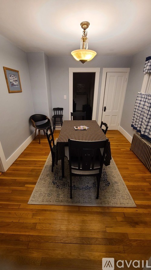 A dining room with a table and chairs.