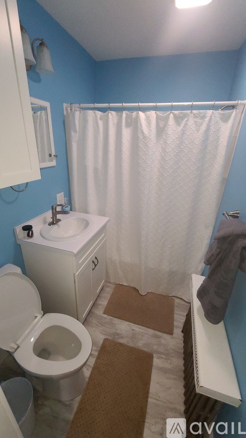 A bathroom with blue walls and a white toilet.