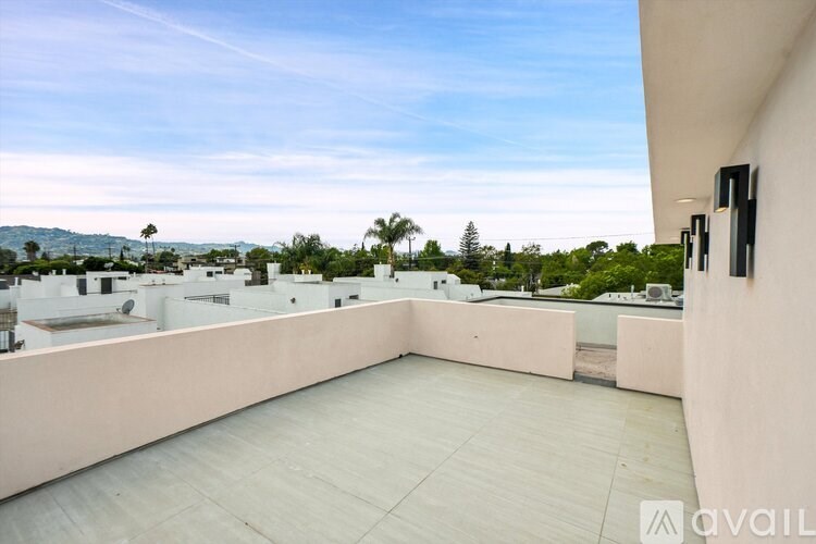 A balcony with a view of the mountains and trees.