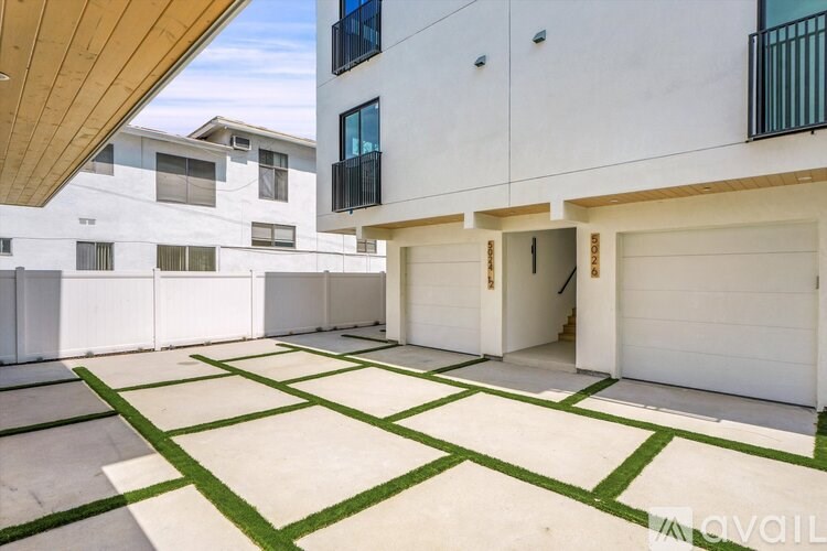A parking lot with green lines and a white building in the background.