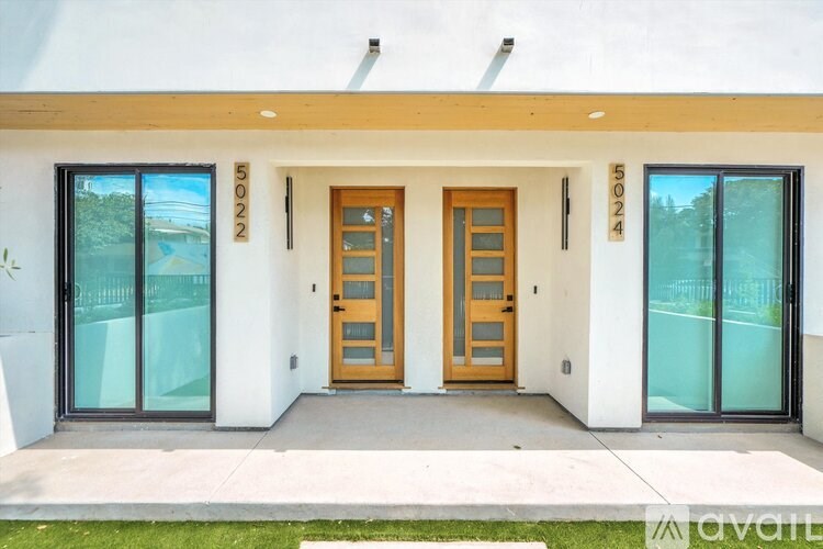 A modern house with a white exterior and a wooden front door.