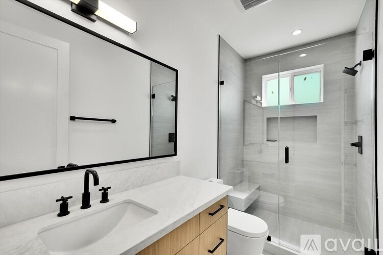 A modern bathroom with a white sink and a large mirror.
