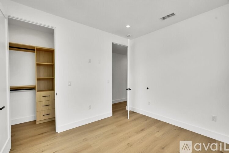 A white room with a door and a drawer unit.