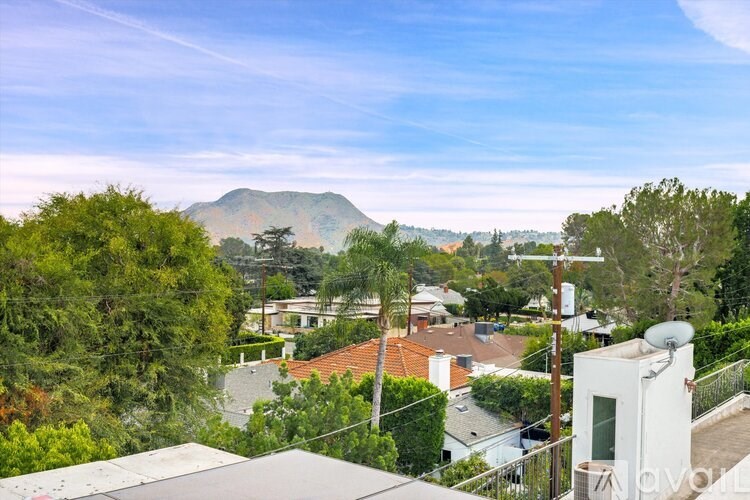 A residential area with houses and a mountain in the background.